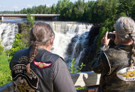 2 motorcycle riders taking a photograph of a waterfall